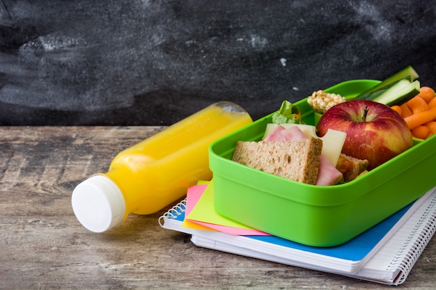 Gezonde schoolmaaltijd Sandwich, groenten, fruit en sap op houten lijst, copyspace