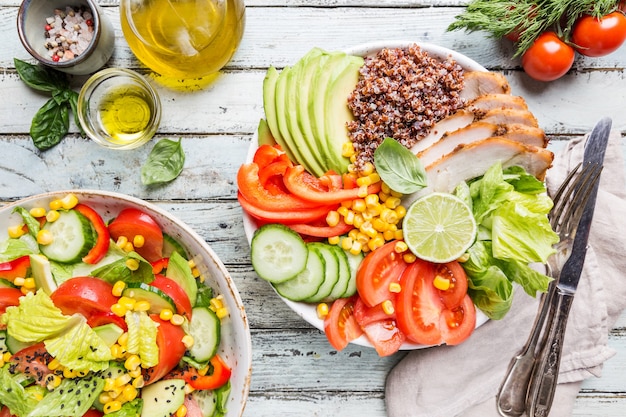 Gezonde slakom met quinoa, tomaat kalkoen, avocado, paprika, maïs, limoen en gemengde greens, bovenaanzicht. Gezonde voedselconceptie. Superfood maaltijd.