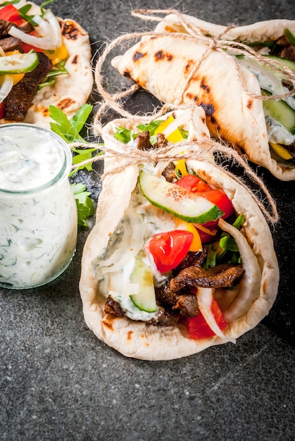 Gezonde snack, lunch. traditionele griekse verpakte sandwichgyros - tortilla's, broodpita met een vulling van groenten, rundvlees en saus tzatziki