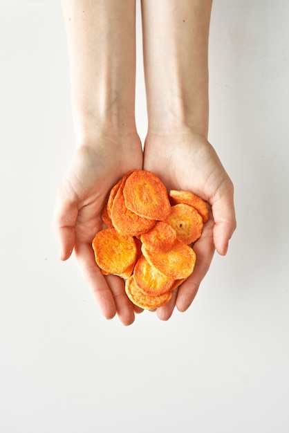 Gezonde snack van droge wortel in geïsoleerde handen