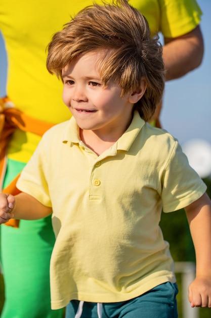 Gezonde sportactiviteit voor kinderen. Vader en zoon sporten en rennen. Sport voor kinderen, actief kind rennen. Kid rennen op buiten. Kind loopt in het stadion. Joggen voor kind.