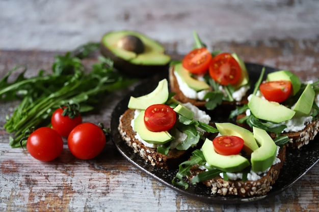 Gezonde toast met avocado en cherrytomaatjes op een plaat