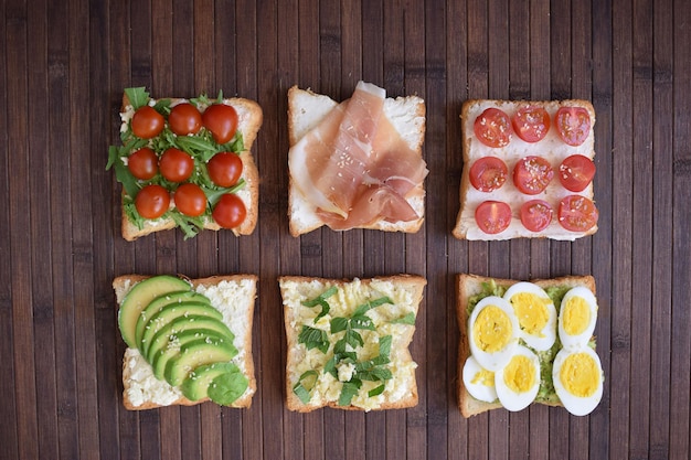 Gezonde toast voor het ontbijt met avocado-eieren, tomaten, rucola enz