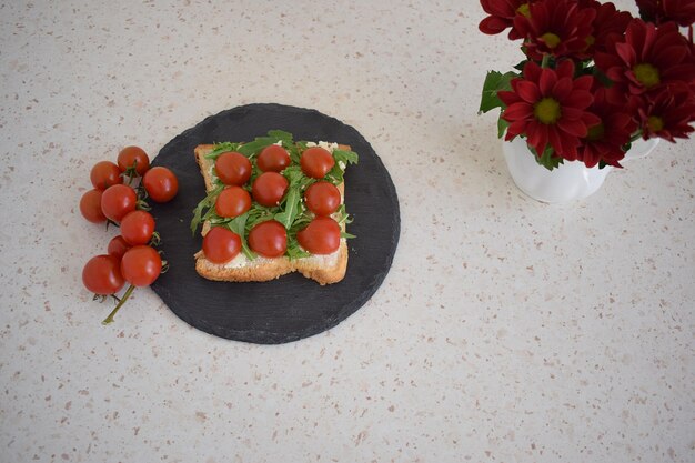 Gezonde toast voor het ontbijt met avocado, eieren, tomaten, rucola enz.