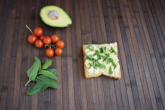 Gezonde toast voor het ontbijt met avocado, eieren, tomaten, rucola enz.