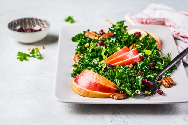 Gezonde vegan salade met appel, cranberry, boerenkool en pecannoten in een rechthoekige plaat.