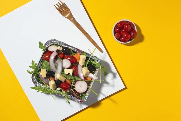 Gezonde veganistische afhaalsalade in aluminium bak of bezorging. Van boven