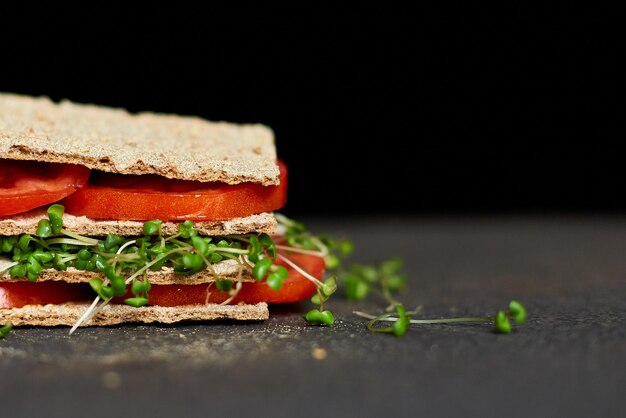 Gezonde veganistische sandwich met knapperige roggebroodtomaat en microgreens