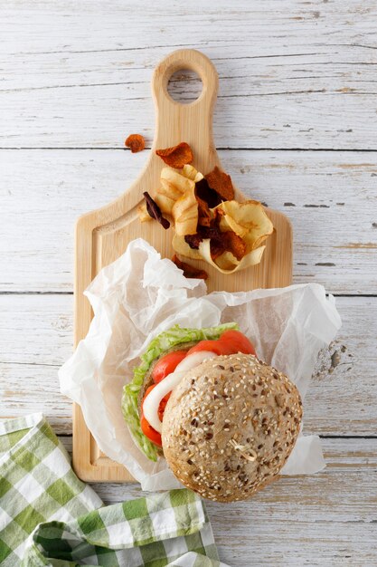 Gezonde veganistische tofuburger met spinazie, sla, tomaat, ui en gebakken groenten