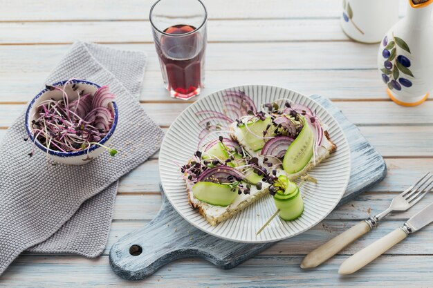 Gezonde vegetarische bruschetta's met brood, microgroenten, kaas, komkommers en rode ui