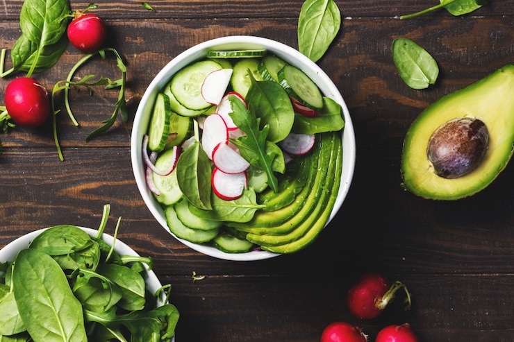 Foto gezonde vegetarische salade met avocado, radijs, spinazie en komkommer