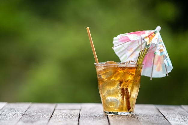 Gezonde, verfrissende drank van kaneel en citroengrasstengels op een houten tafel in een tropische tuin.