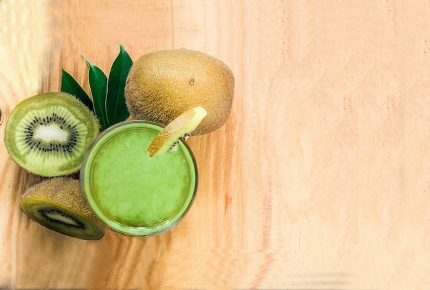 Gezonde verse kiwi smoothie in glas op een houten achtergrond