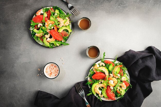 Gezonde verse salade met garnalen, avocado, grapefruit, rucola en cashewnoten grijze stenen keukentafel achtergrond bovenaanzicht kopieerruimte