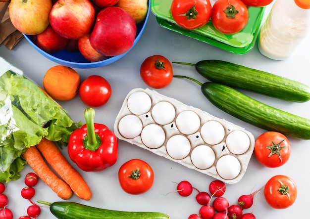 gezonde voeding achtergrond, groenten, fruit, eieren en zuivelproducten op witte tafel, bovenaanzicht