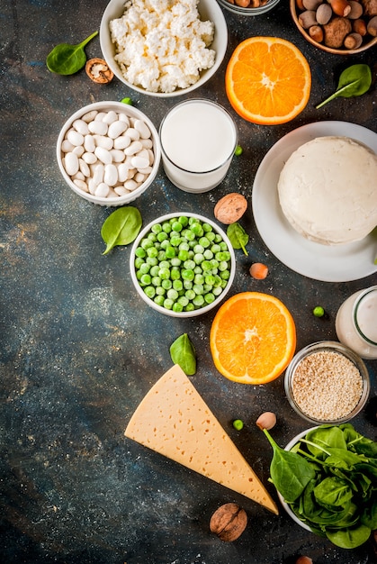 Gezonde voeding concept. Set van voedsel rijk aan calcium - zuivel en veganistische Ca-producten donkerblauwe achtergrond