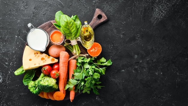 Gezonde voeding, fruit en groenten. Broccoli, Wortelen, melk, kaas, spinazie, gedroogde abrikozen, peterselie, tomaten. Bovenaanzicht.