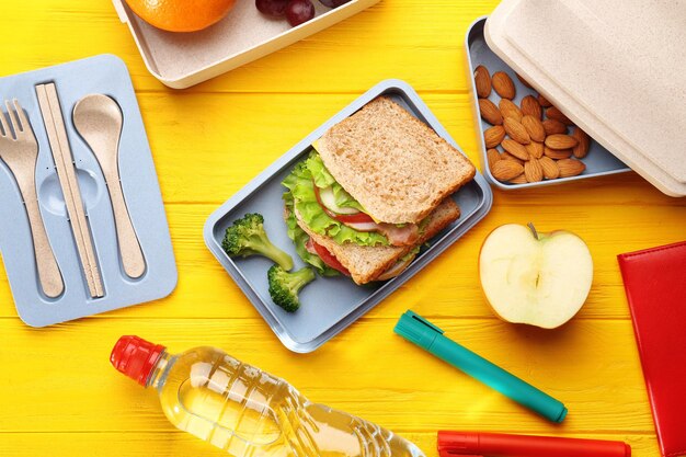 Foto gezonde voeding in de lunchbox op gele houten achtergrond