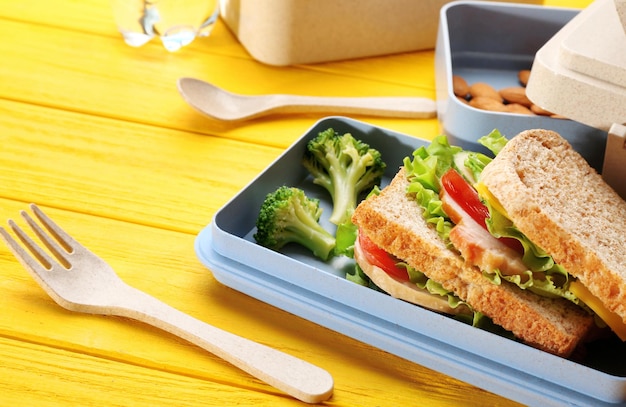 Gezonde voeding in lunchboxen op gele houten achtergrond