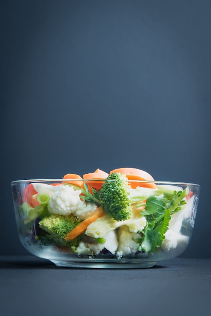 Gezonde voeding ligt op tafel, verse groentesalade in een glazen boog