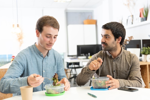 Gezonde voeding op de werkplek concept Twee collega's lunchen op kantoor