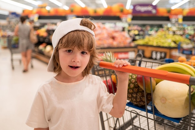 Gezonde voeding voor jong gezin met kinderen jongen bij supermarkt of supermarkt portret van grappige kleine