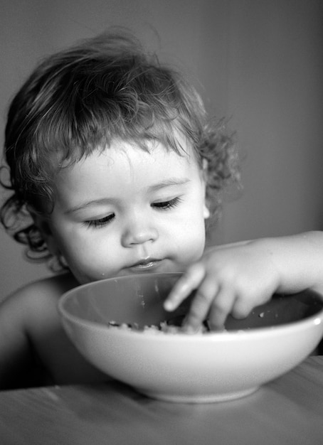 Gezonde voeding voor kinderen portret van schattig blank kind kind met lepel hongerige rommelige baby met