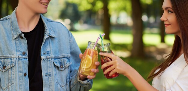 Gezonde voeding. Vrienden die vers sapdetox drinken op groene natuurachtergrond