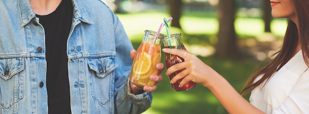 Gezonde voeding. Vrienden die vers sapdetox drinken op groene natuurachtergrond