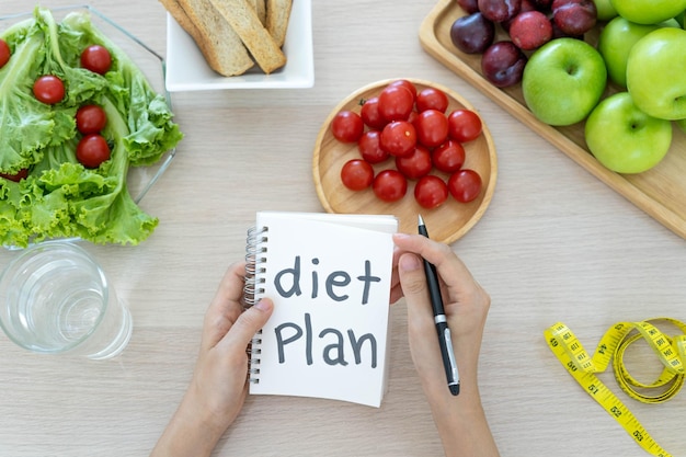 Gezonde voeding Vrouwen plannen een dieet voor een slanke vorm en gezond Vrouw die groentensalade en tomaten eet