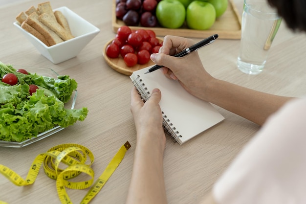 Gezonde voeding Vrouwen plannen een dieet voor een slanke vorm en gezond Vrouw die groentensalade en tomaten eet