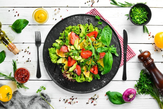 Gezonde voedselsalade van rucola, avocado, aardbei en sinaasappel Bovenaanzicht Vrije ruimte voor uw tekst