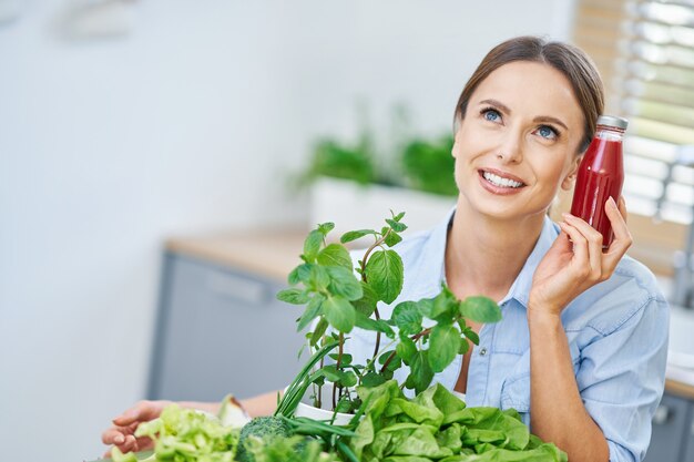 gezonde volwassen vrouw met groen voedsel in de keuken