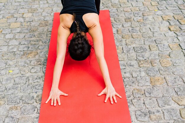 Gezonde vrouw in sportkleding die buiten yoga beoefent, oefeningen doet, portret van volledige lengte.