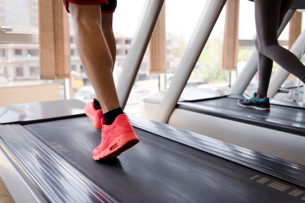 Gezonde yung sportman oefening joggen op loopband in fitness gym