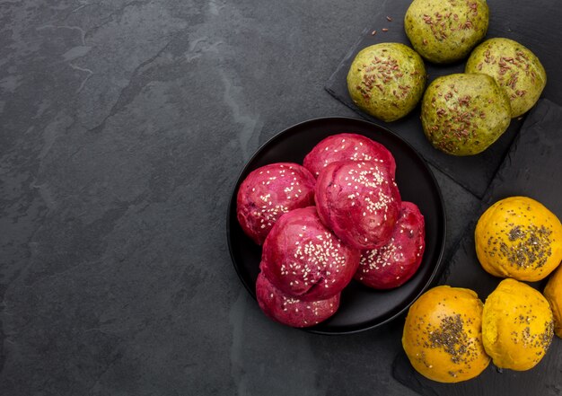 Gezonde zelfgemaakte gekleurde broodbroodjes voor hamburgers. Purpere bootroot, groene spinazie en gele kurkumeburgersbroodjes, hoogste mening, exemplaarruimte.