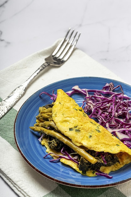 Gezonde zelfgemaakte groene asperges omelet met spinazie en paarse kool met kopie ruimte. Veganistisch voedselconcept