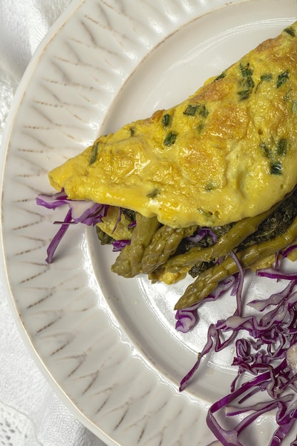 Gezonde zelfgemaakte groene asperges omelet met spinazie en paarse kool met kopie ruimte. Veganistisch voedselconcept