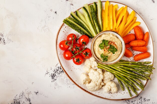 Gezonde zelfgemaakte hummus met diverse verse groenten.