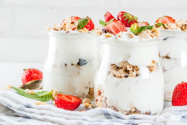 Gezonde zomer ontbijt idee, zelfgemaakte gelaagde parfe dessert in kleine pot