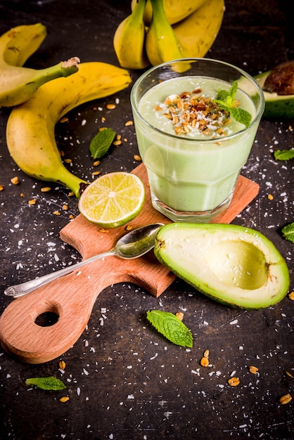 Gezonde zomerse drank, avocado en banaan smoothie met limoen, muesli en kokosmelk