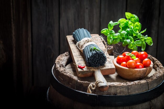 Gezonde zwarte spaghetti met basilicum en tomaten