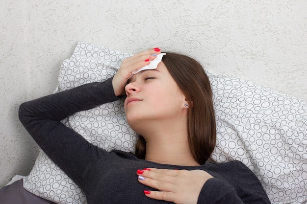 Gezondheid en geneeskunde. Een jong meisje is ziek thuis in bed.