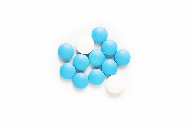 Gezondheid en medicijnconcept blauwe en witte pillendrug of tabletten op wit met exemplaarruimte