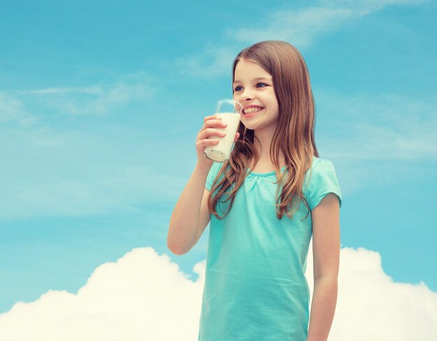 gezondheid en schoonheidsconcept - glimlachend meisje dat melk drinkt uit glas