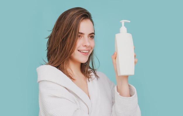 Gezondheid haar en schoonheidsconcept vrouw houdt fles shampoo en conditioner schoonheidsproduct vast