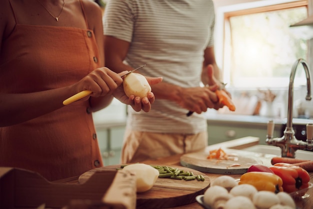 Foto gezondheidsdieet en voedsel van een paar dat samen een maaltijd kookt voor de lunch in de keuken thuis man en vrouw in een relatie die als een team werken om verse biologische groenten te koken voor gezonde voeding