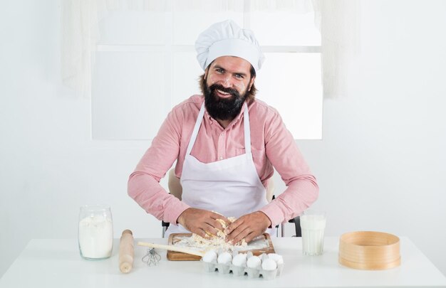 Gezondheidsvoordelen professionele restaurantkok bakken bekwame bakker gebruik keukengerei voor het koken mannelijke chef-kok in hoed gezonde maaltijd bereiden knappe man met baard en snor kookvoedsel