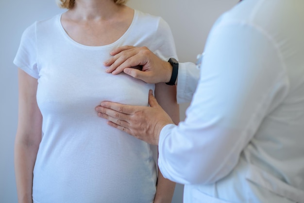 Gezondheidswerker die de borstklier van een vrouwelijke patiënt onderzoekt