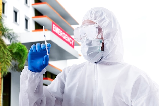 Gezondheidswerker met een beschermend pak en handschoenen met een spuit in het ziekenhuis